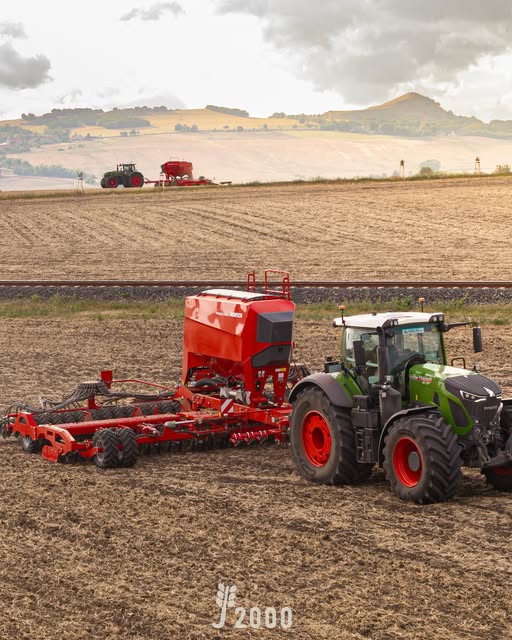 Traktor und rote Sämaschine im Einsatz auf dem Feld